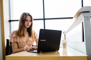 Frau mit Unzufriedenheit im Job am Schreibtisch sitzend mit Laptop